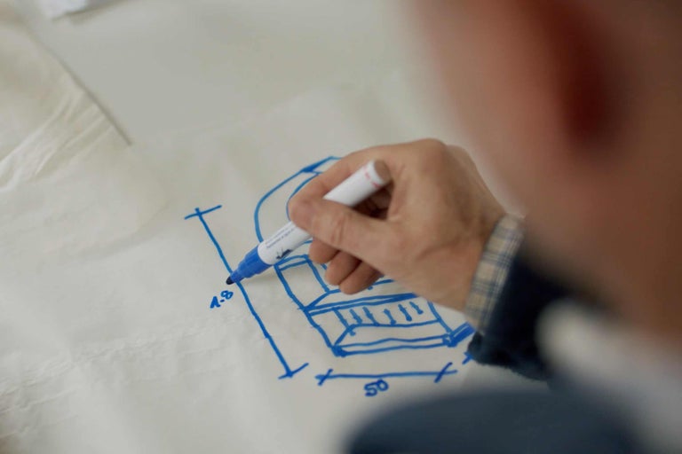 Hand zeichnet Sofaskizze mit blauer Farbe auf Papier