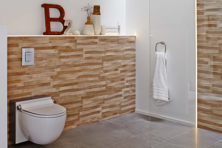 Salle de bain moderne avec WC suspendu, lambris en bois et porte-serviettes.