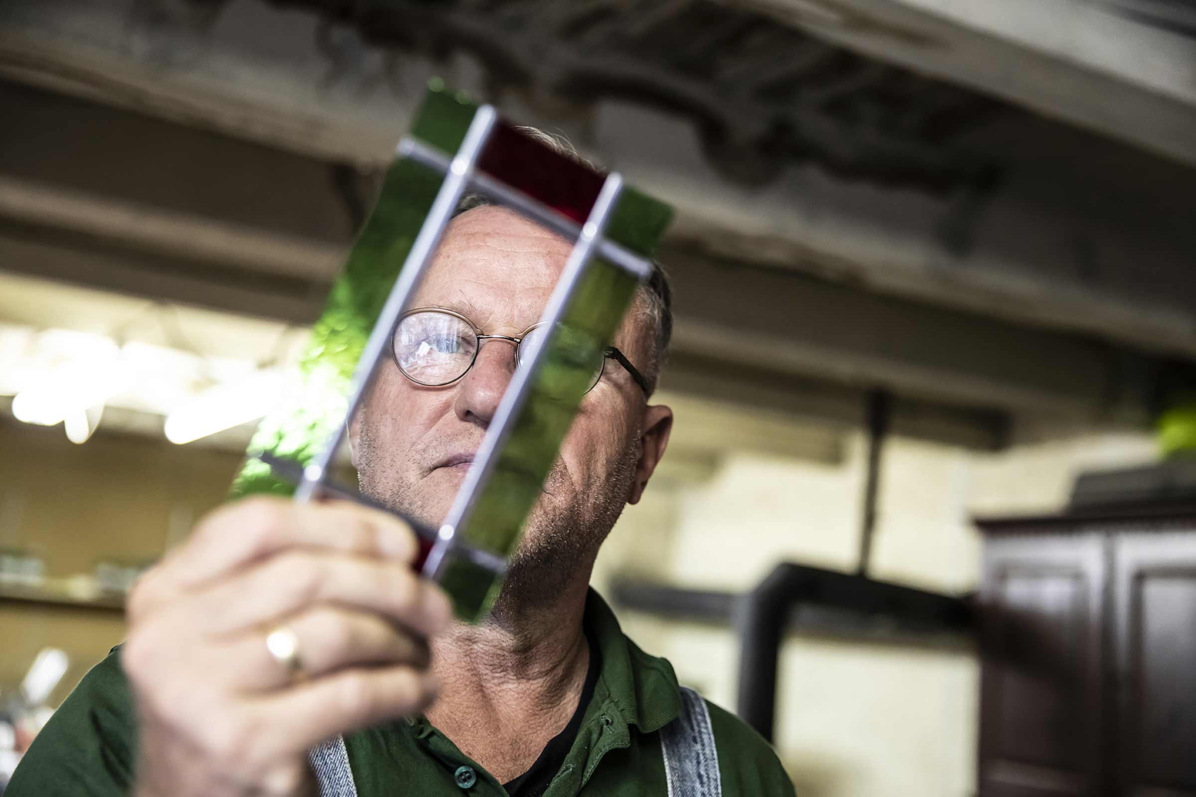 Mann betrachtet Glasstück für Glasarbeiten