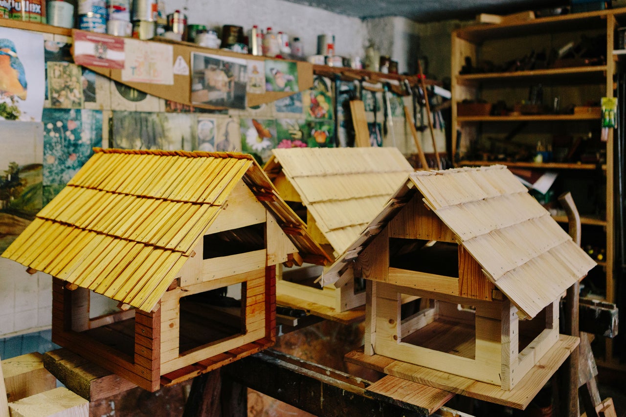 Trois nichoirs en bois avec toit en bardeaux dans un atelier