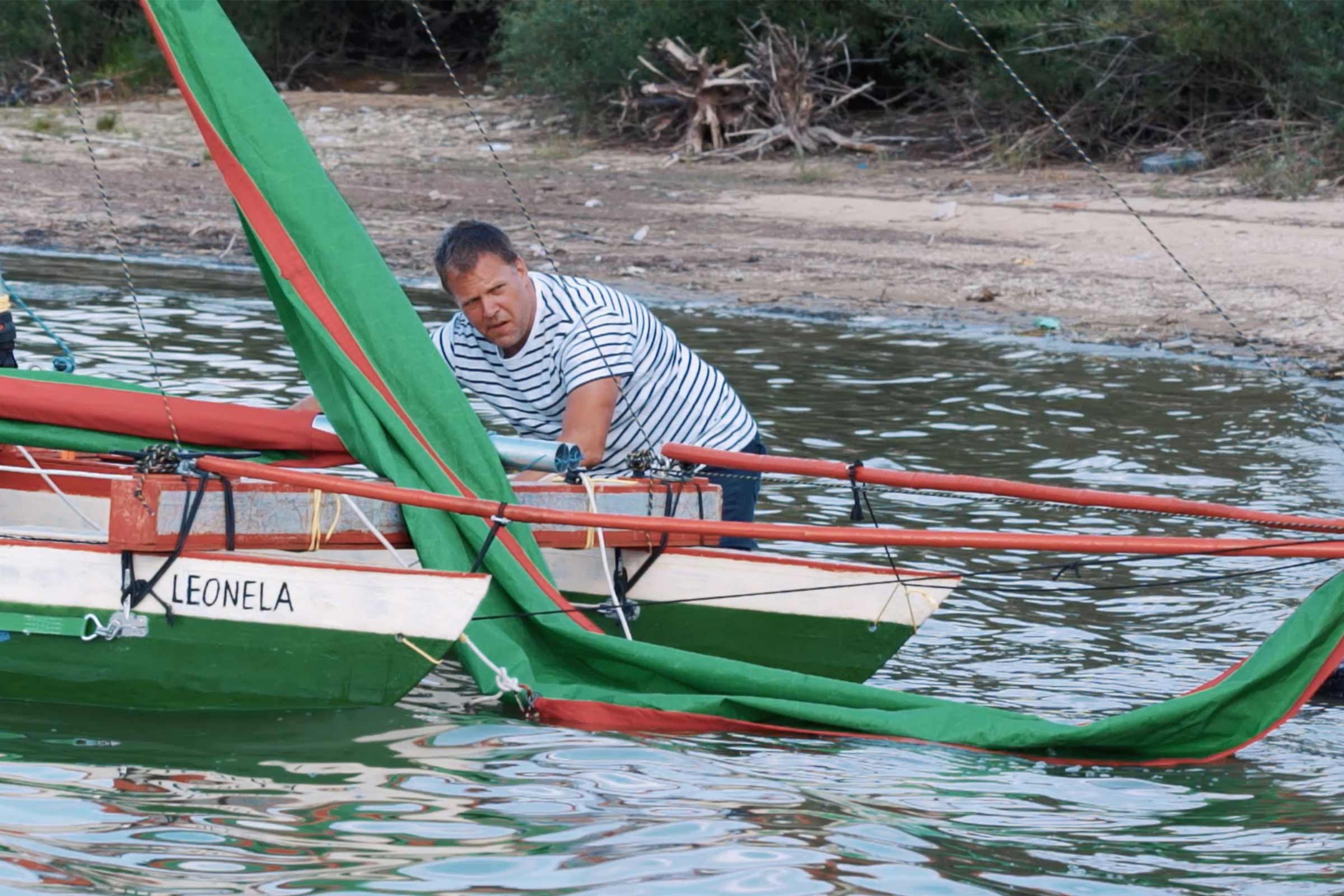 Un homme prépare un voilier pour la navigation