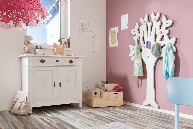 Kinderzimmer mit Kommode, Baumgarderobe und Spielzeugkisten