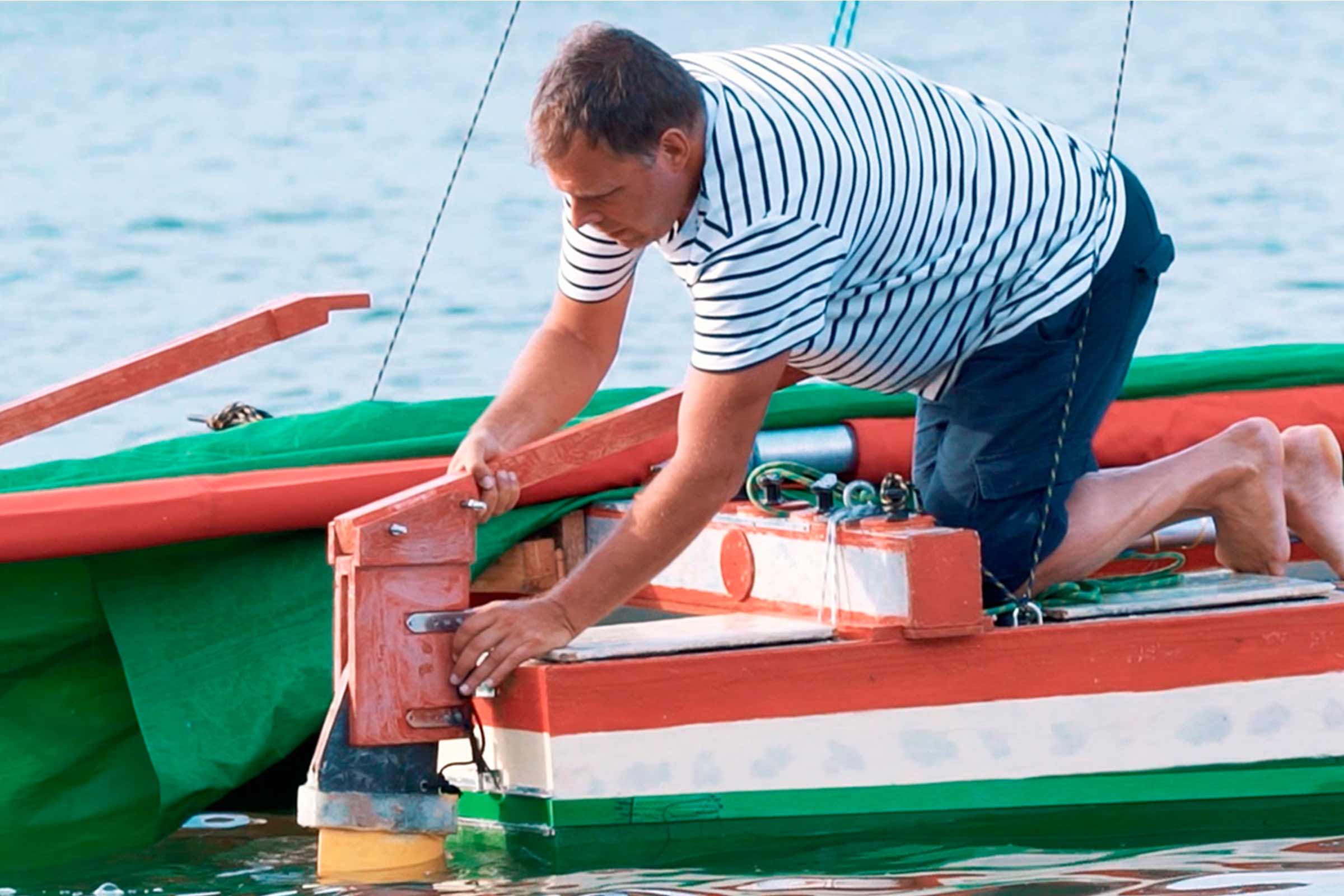 Homme réparant un bateau dans l'eau