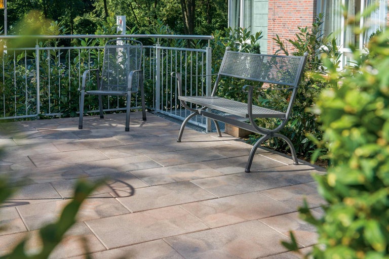 Terrasse avec dalles en pierre, banc de jardin et chaise