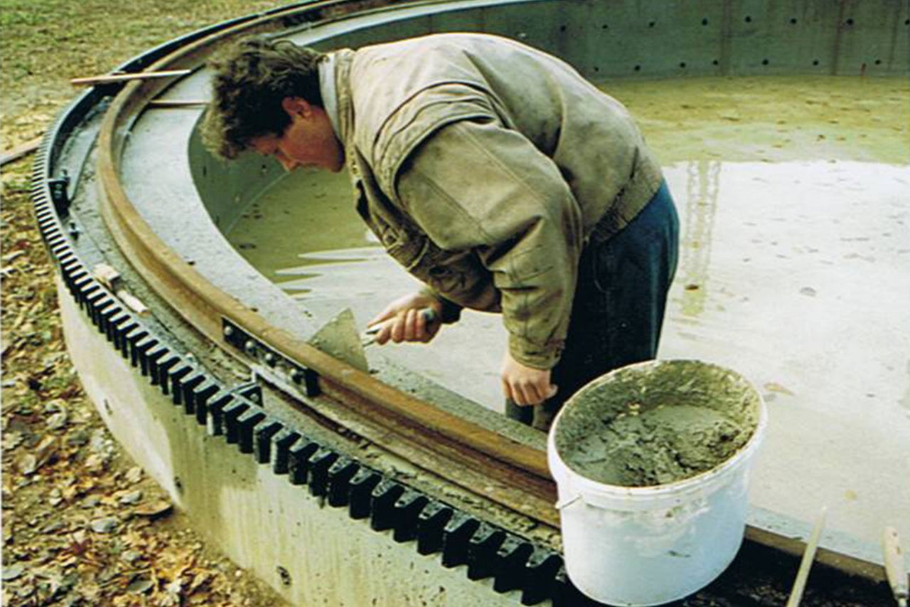 Homme travaillant sur une structure en béton avec un engrenage