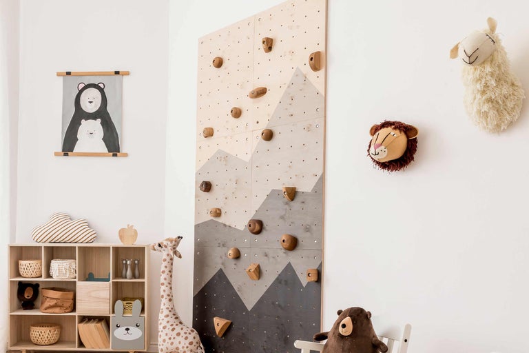 Chambre d'enfant avec mur d'escalade, étagère à jouets et peluches