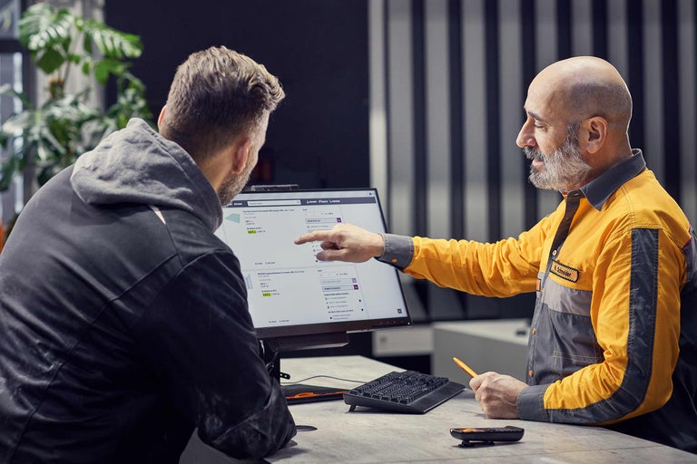 Un collaborateur Hornbach conseille un client sur des produits à l'ordinateur.