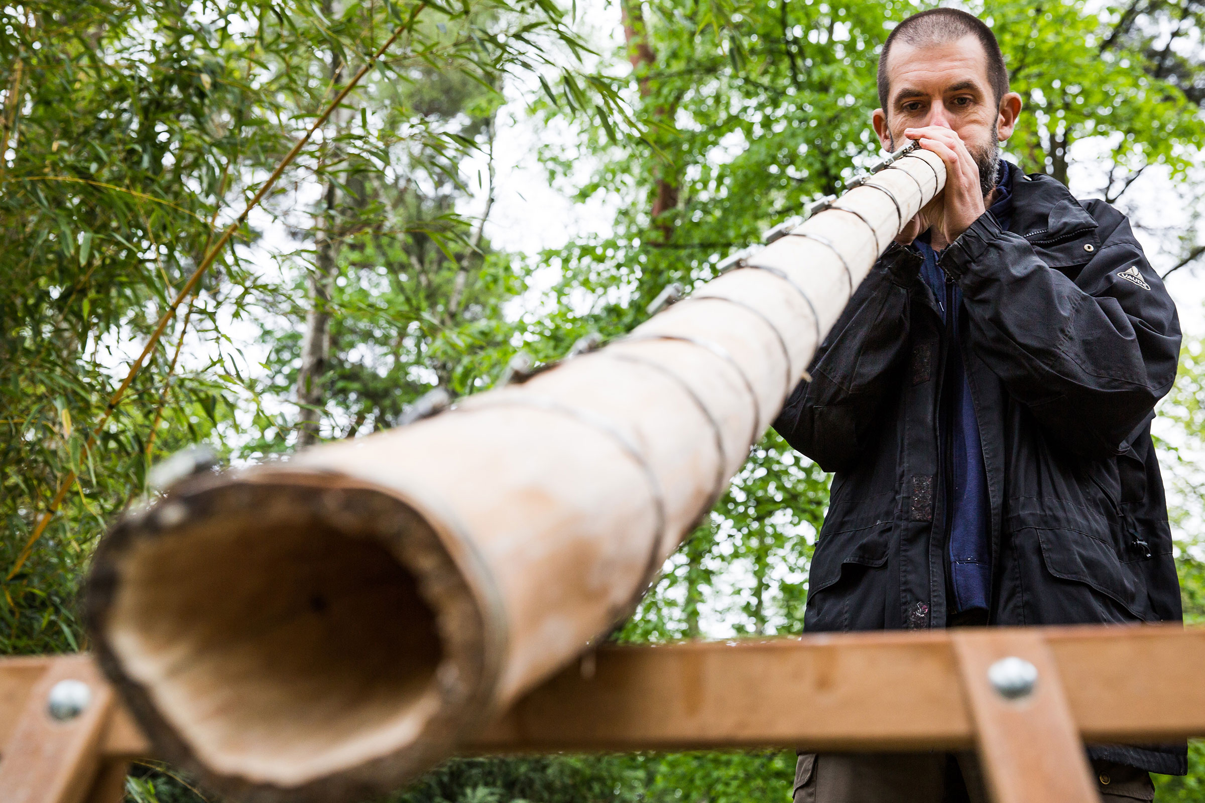 Mann spielt Didgeridoo aus Bambus im Freien.