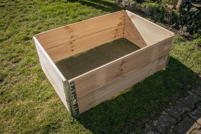 Hochbeet aus Holz mit Metallecken auf einer Wiese