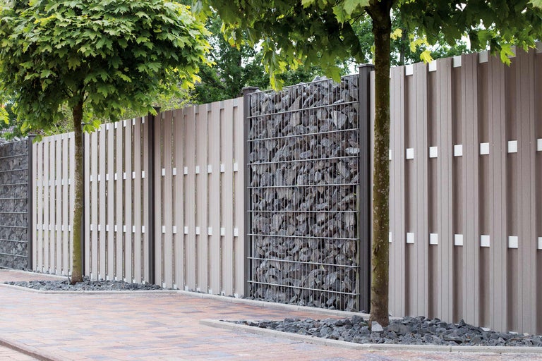 Gartenzaun aus Kunststoff und Gabionen mit Steinen gefüllt