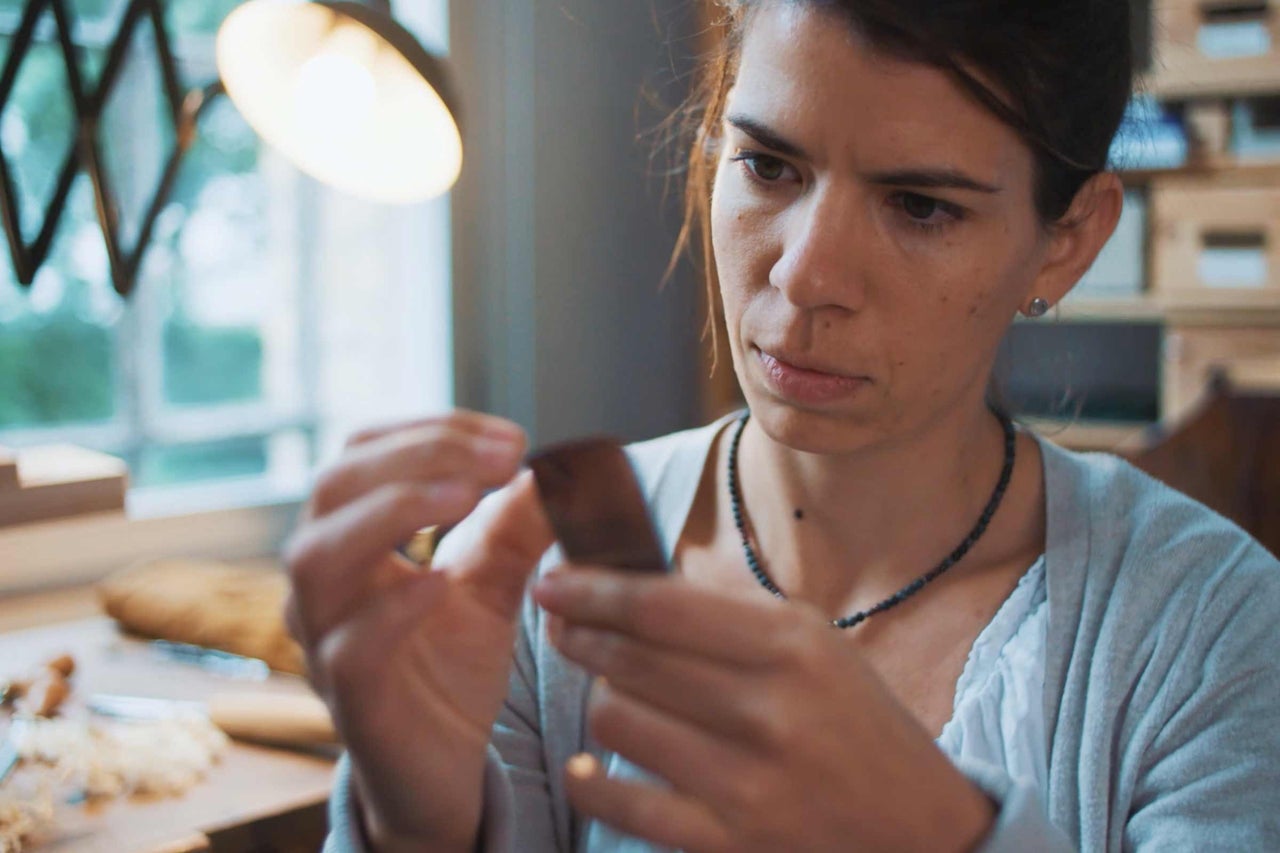 Femme examinant un morceau de bois dans un atelier
