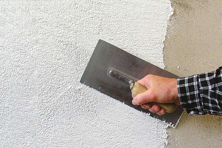 Aussenputz wird mit einer Glättkelle aufgetragen