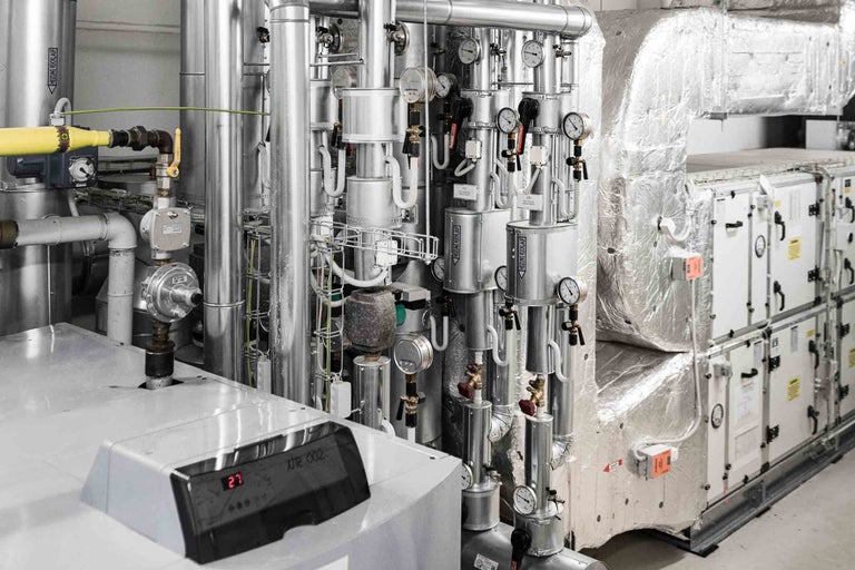 Système complexe de chauffage et de ventilation avec tuyaux, appareils de mesure et unités de commande.