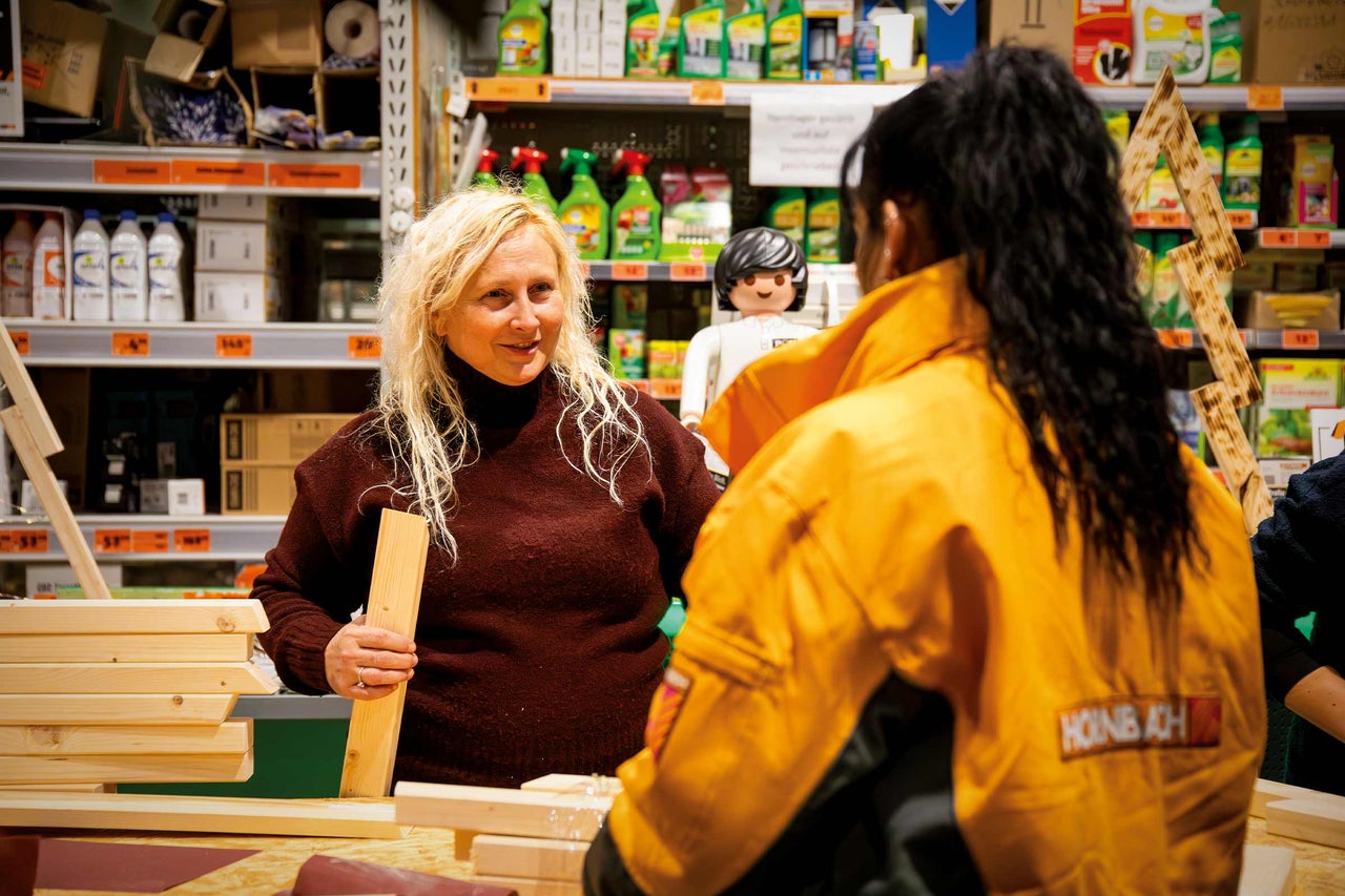 Conversation client dans le magasin Hornbach devant des étagères avec des produits