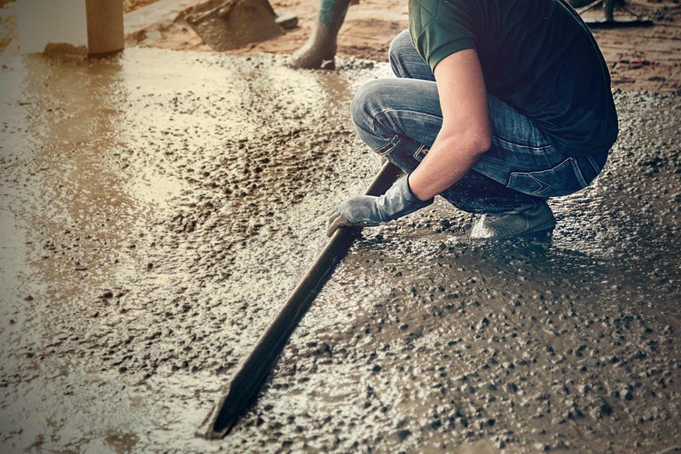 Une personne lisse le béton avec un outil