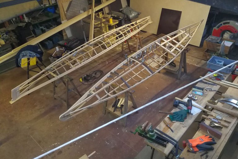 Deux canoës en bois en construction dans un atelier