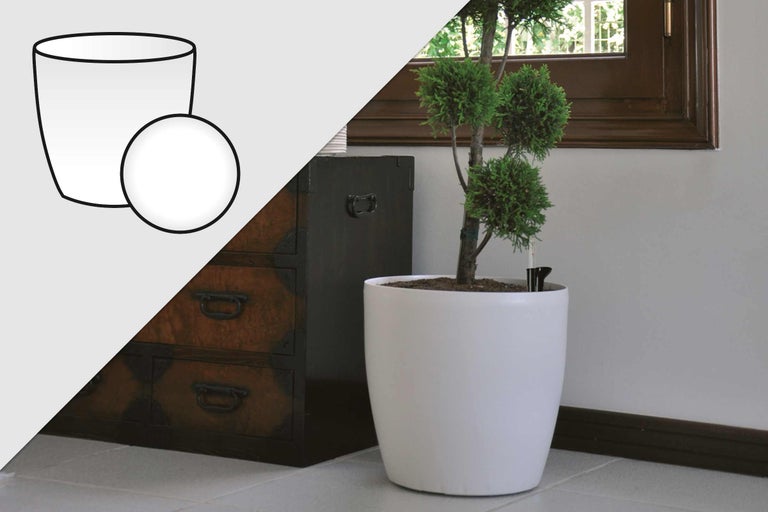 Weisser Blumentopf mit Bewässerungssystem und Pflanze