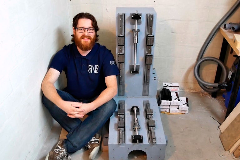 Une personne est assise à côté d'un kit de construction de machine CNC sur la boutique en ligne Hornbach.