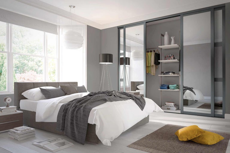 Helles Schlafzimmer mit Bett, Kleiderschrank und Fenster für eine freundliche Atmosphäre