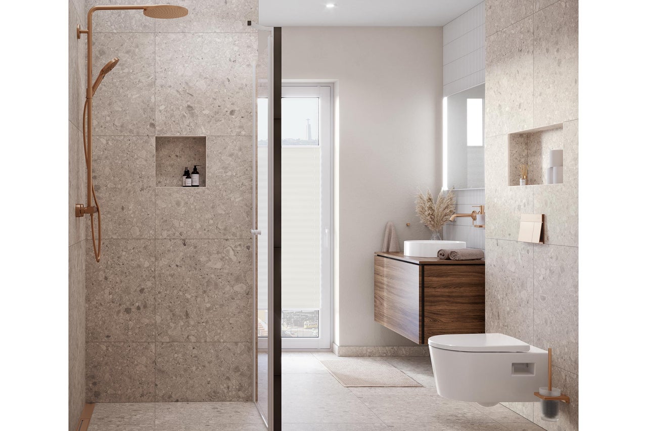 Modernes Badezimmer mit grossformatigen Fliesen in Natursteinoptik, ebenerdiger Dusche mit kupferfarbenen Armaturen, Waschtisch und Wand-WC.
