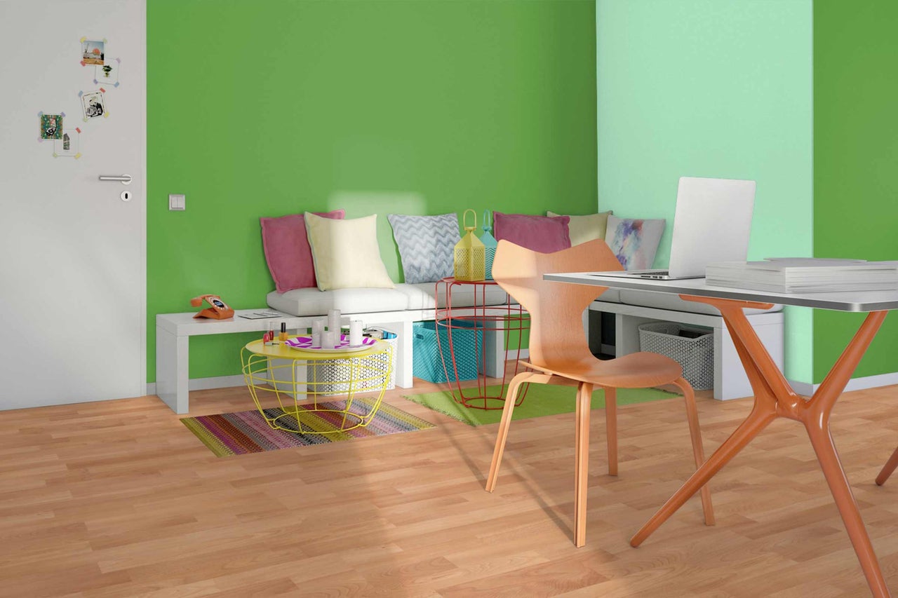 Salon lumineux avec bureau, chaise, canapé et décoration sur parquet