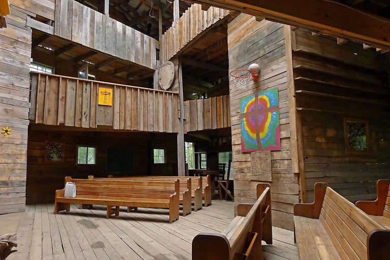 Innenraum eines Holzhauses mit Sitzbänken und Basketballkorb