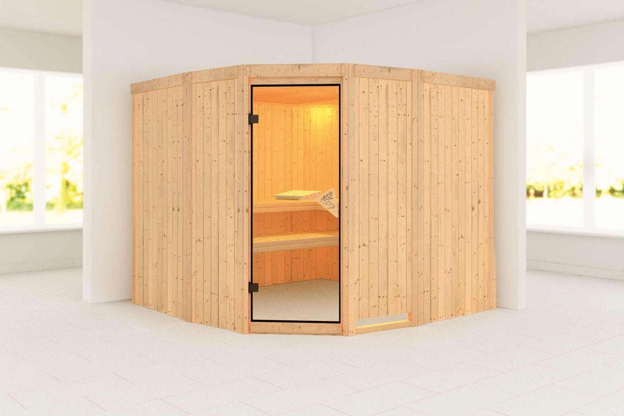 Sauna d'angle en bois avec porte en verre dans une pièce lumineuse.