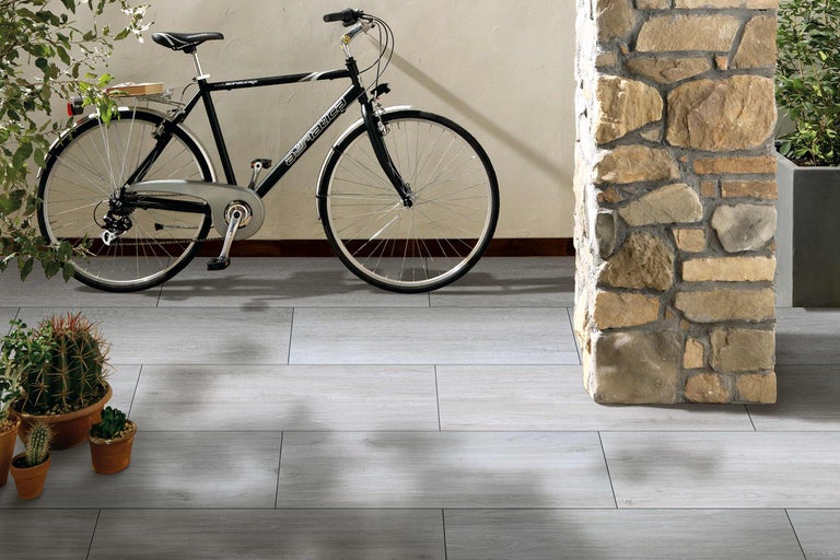 Sol avec aspect carrelage gris, vélo et colonne en pierre