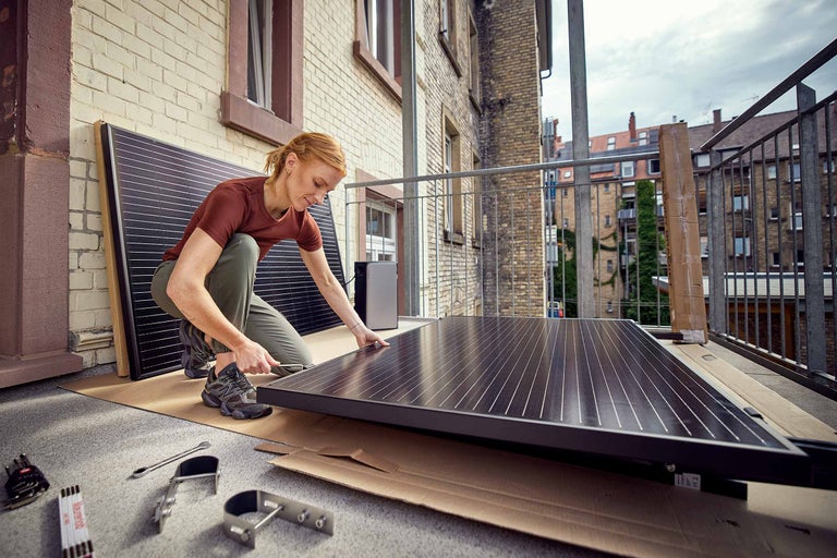 Balkon mit Solarmodulen und Pflanzenkasten