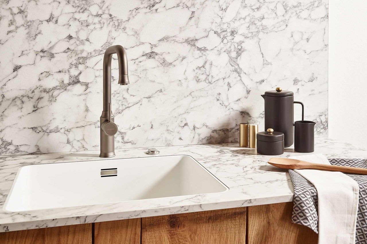 Évier de cuisine avec robinet et ustensiles de cuisine sur un plan de travail en marbre