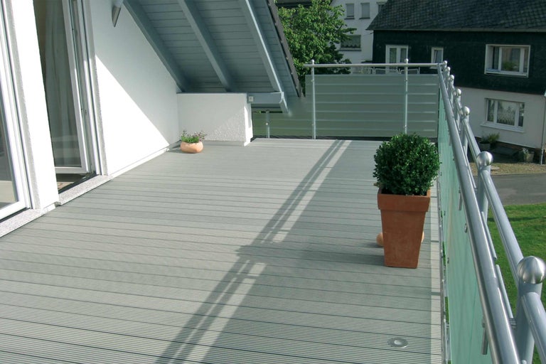 Balcon avec plancher en lames, rambarde et végétation