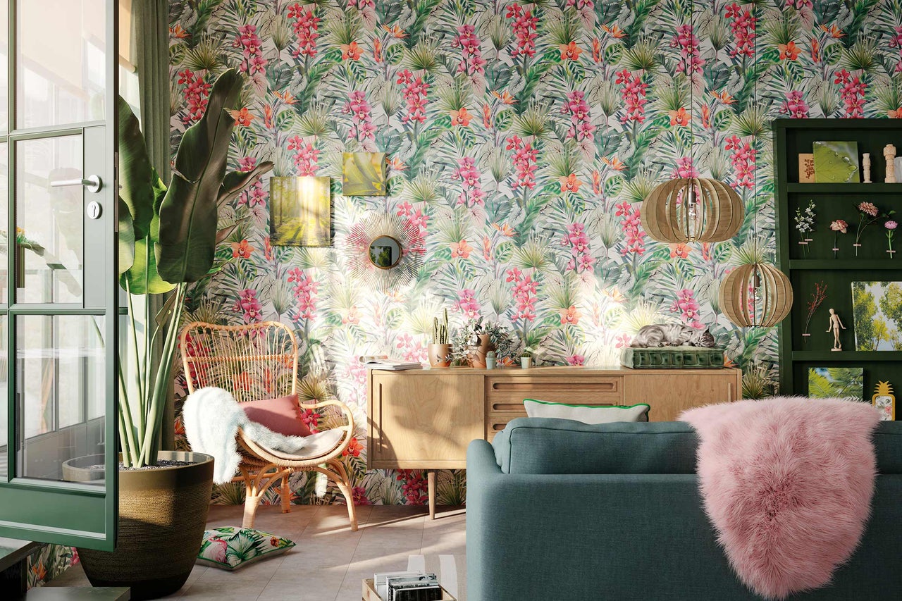 Salon avec papier peint floral, fauteuil en rotin, canapé et éléments en bois