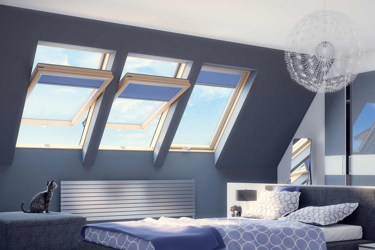 Chambre lumineuse avec fenêtres de toit, radiateur et lampe décorative