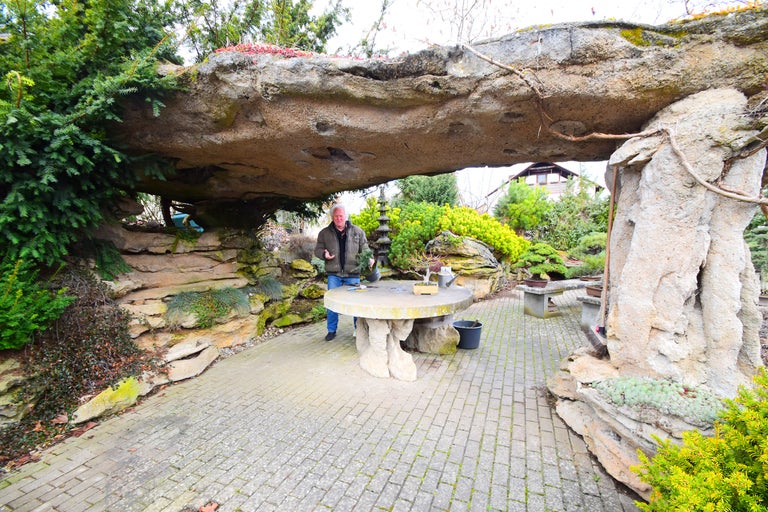 Aménagement extérieur avec table en pierre et toit rocheux dans le jardin