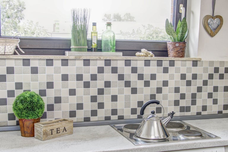 Scène de cuisine avec plaque de cuisson, bouilloire et articles de décoration