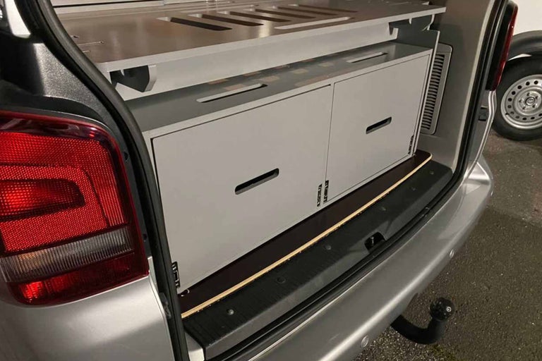 Coffre aménagé d'un van avec tiroirs et étagères
