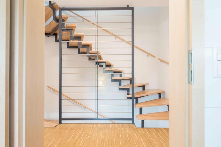 Escalier en bois avec garde-corps en métal dans une pièce lumineuse