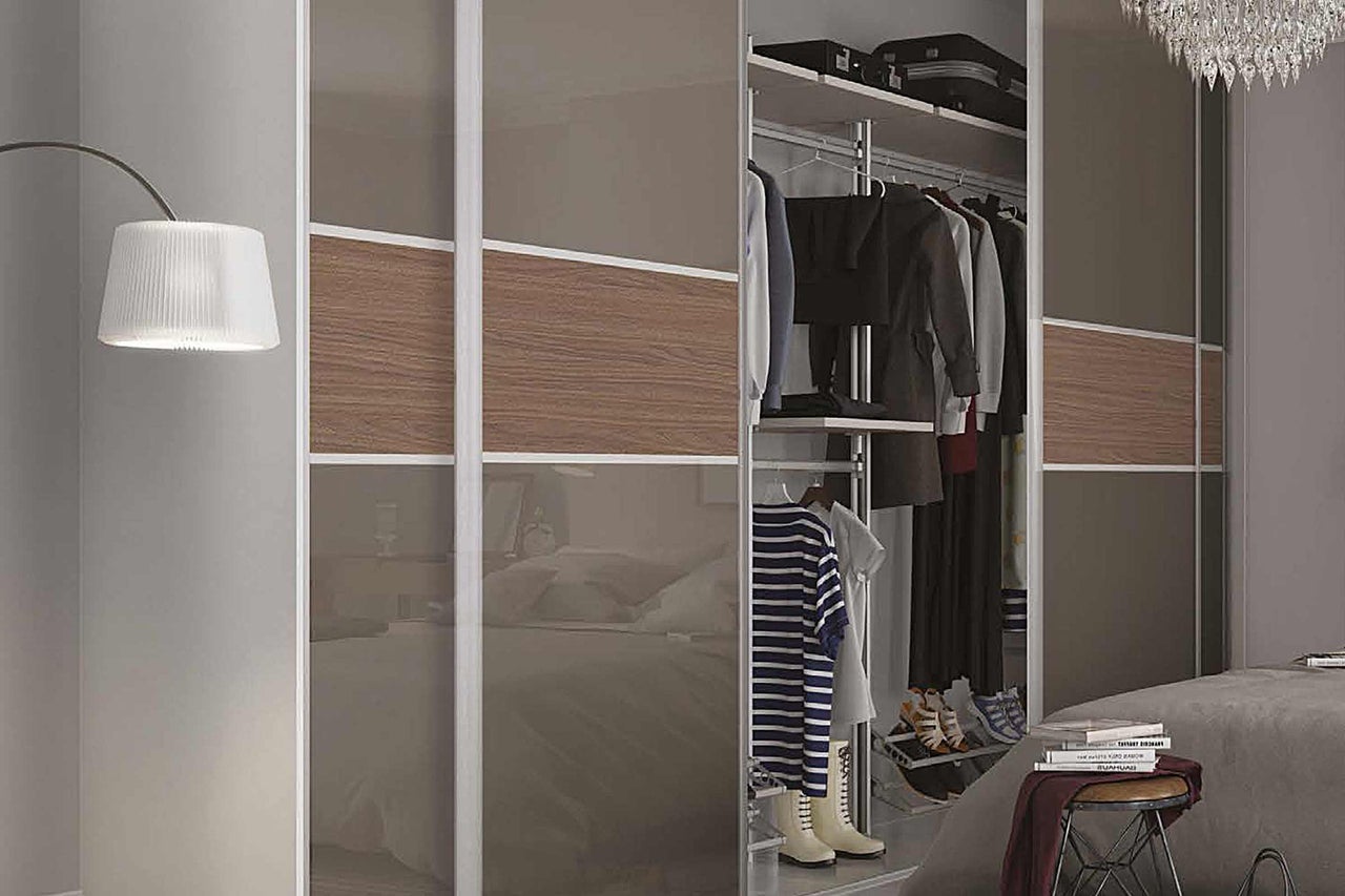 Schlafzimmerszene mit einem Kleiderschrank mit Schiebetüren, Kleidung und Accessoires