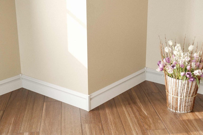 Coin de pièce avec plinthes, parquet et vase de fleurs