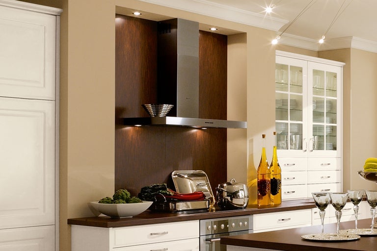 Scène de cuisine avec hotte aspirante, armoires de cuisine et ustensiles de cuisine