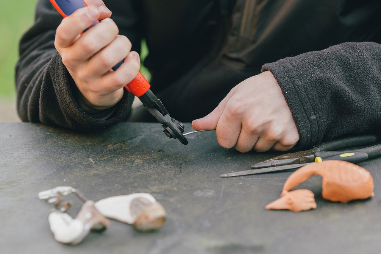 Une personne plie un fil avec une pince