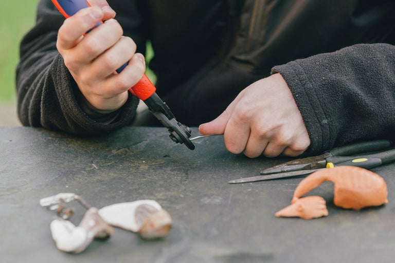 Eine Person biegt einen Draht mit einer Zange