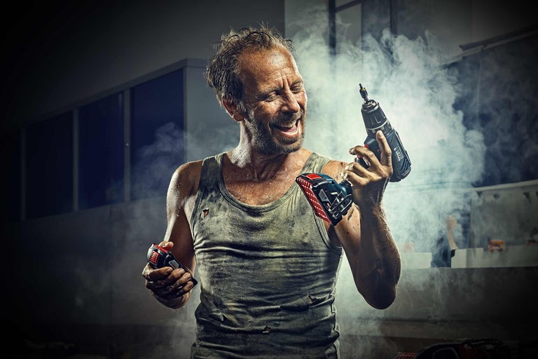 Homme tenant un tournevis sans fil à la main