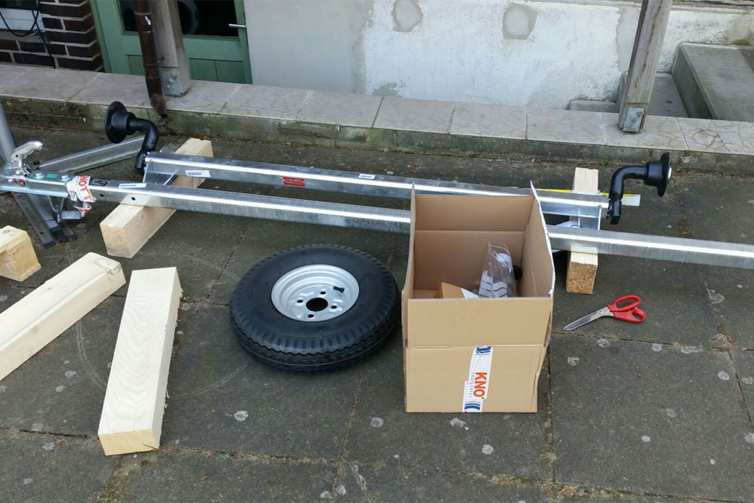 Essieu de remorque avec accessoires, pneu, poutres en bois et carton