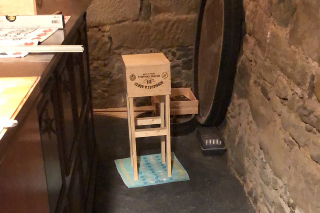 Selbstgebauter Hocker aus einer Weinkiste in einem Kellerraum.