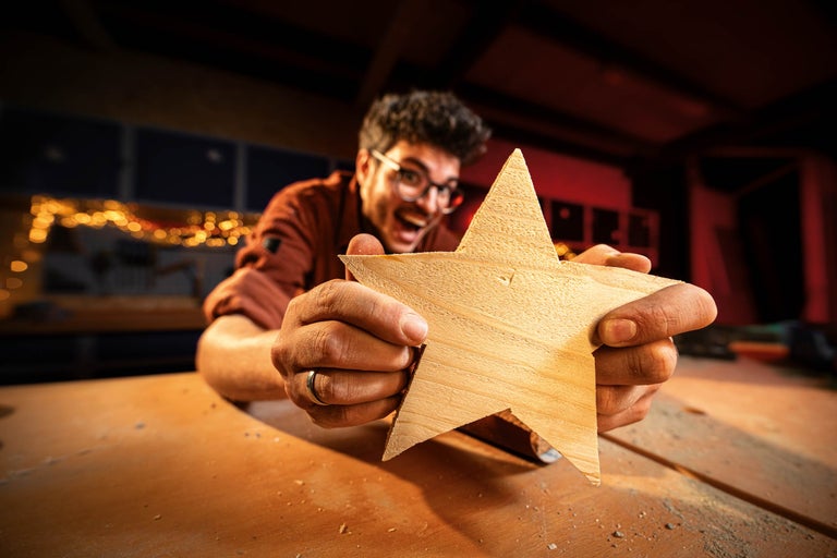 Mann hält einen Holzstern in der Hand