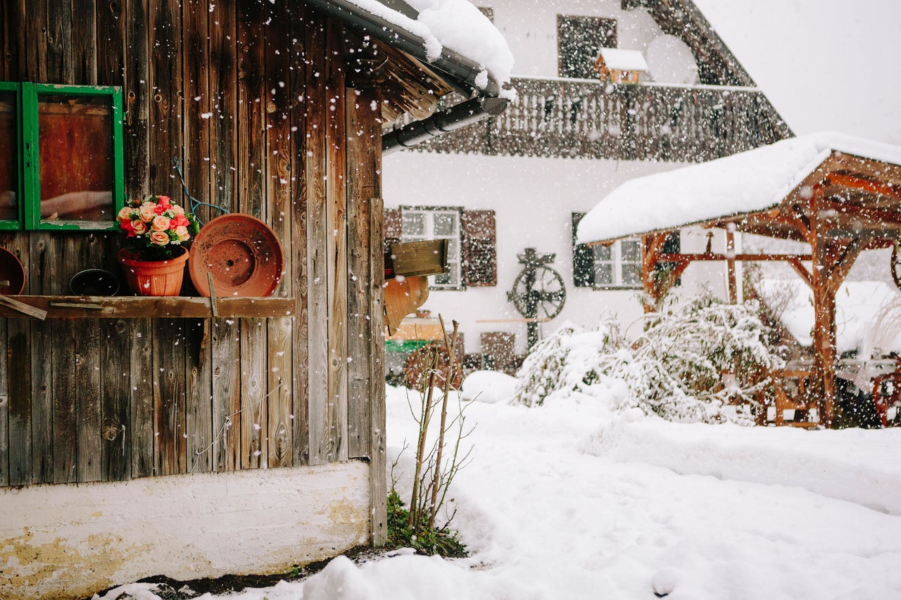 Scène hivernale avec maison, tonnelle de jardin et chute de neige