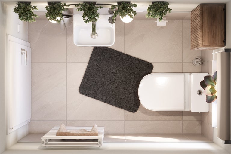 Vue de dessus d'une salle de bains lumineuse avec toilettes, lavabo, tapis de bain et sèche-serviettes