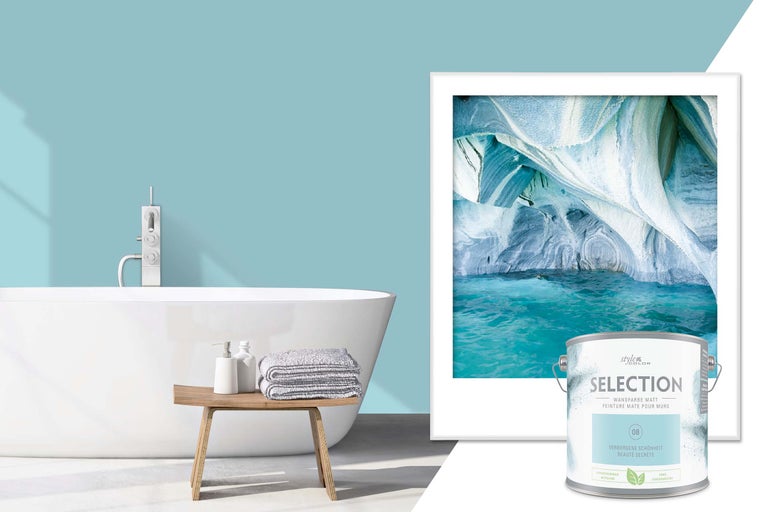 Badezimmerszene mit Badewanne, Hocker mit Handtüchern, Wandbild und Dose Wandfarbe