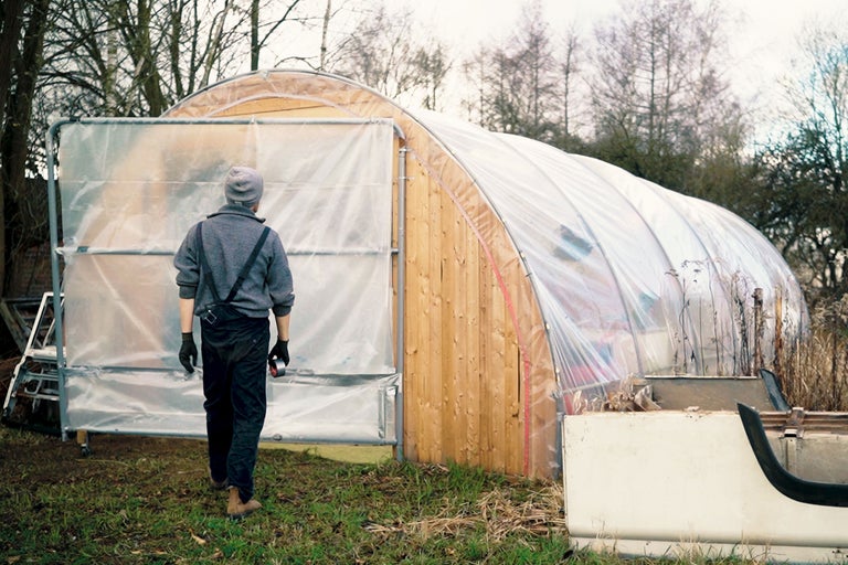 Gewächshaus mit Holzrahmen und transparenter Folie, im Aussenbereich